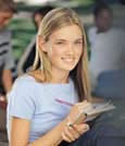 Girl reviewing a school with pen and paper in hand and smiling